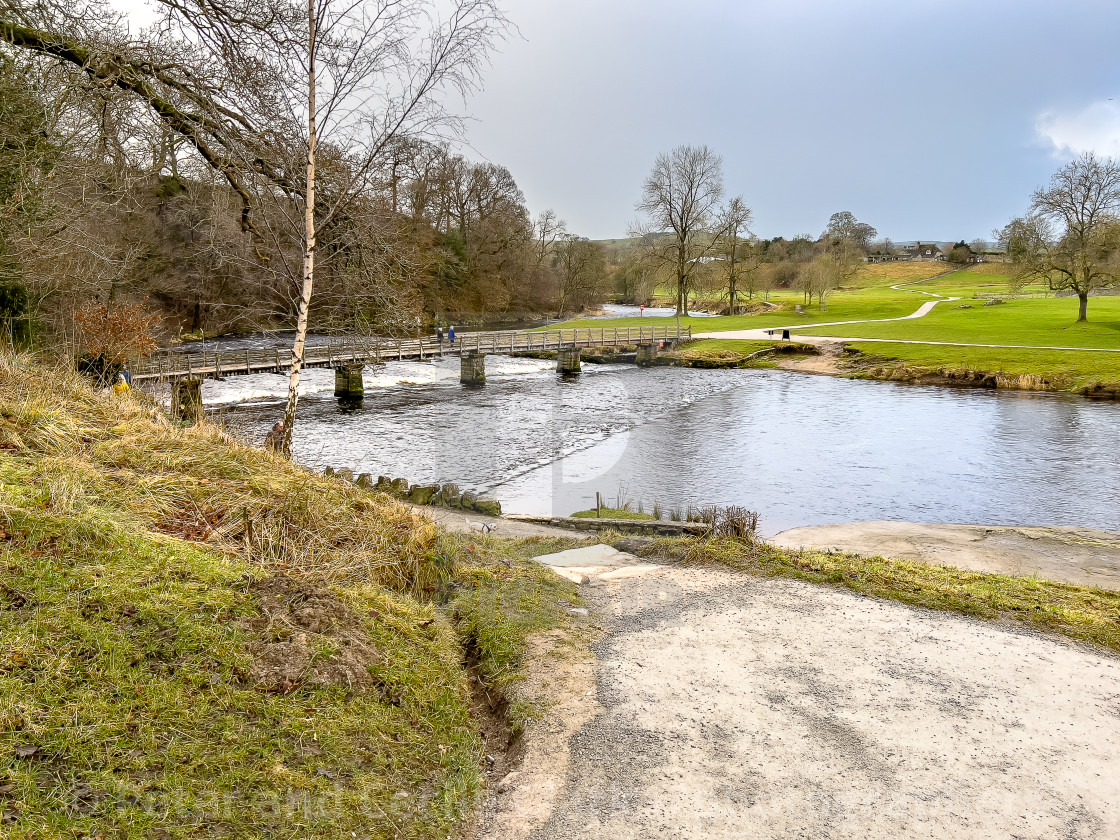 "River Wharfe, Footbridge, Bolton Abbey, Priory Ruins in the Background." stock image