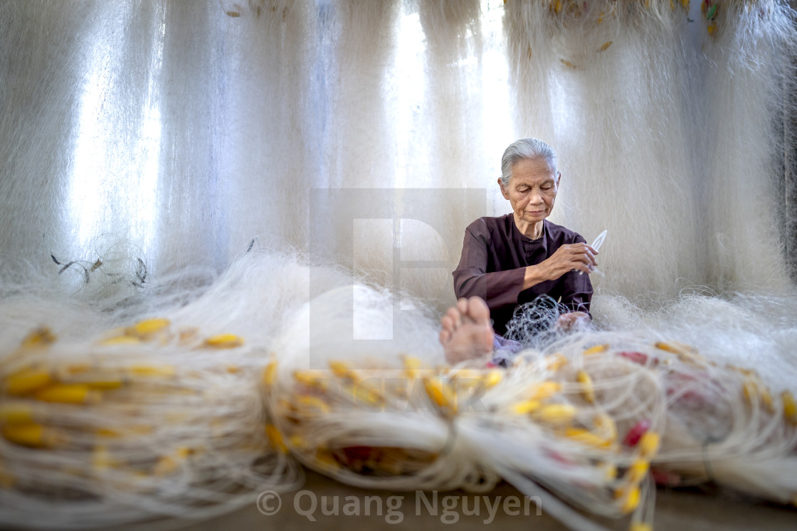"an elderly woman sitting mending a fishing net" by Quang Nguyen - $43.35 "an elderly woman sitting mending a fishing net" stock image