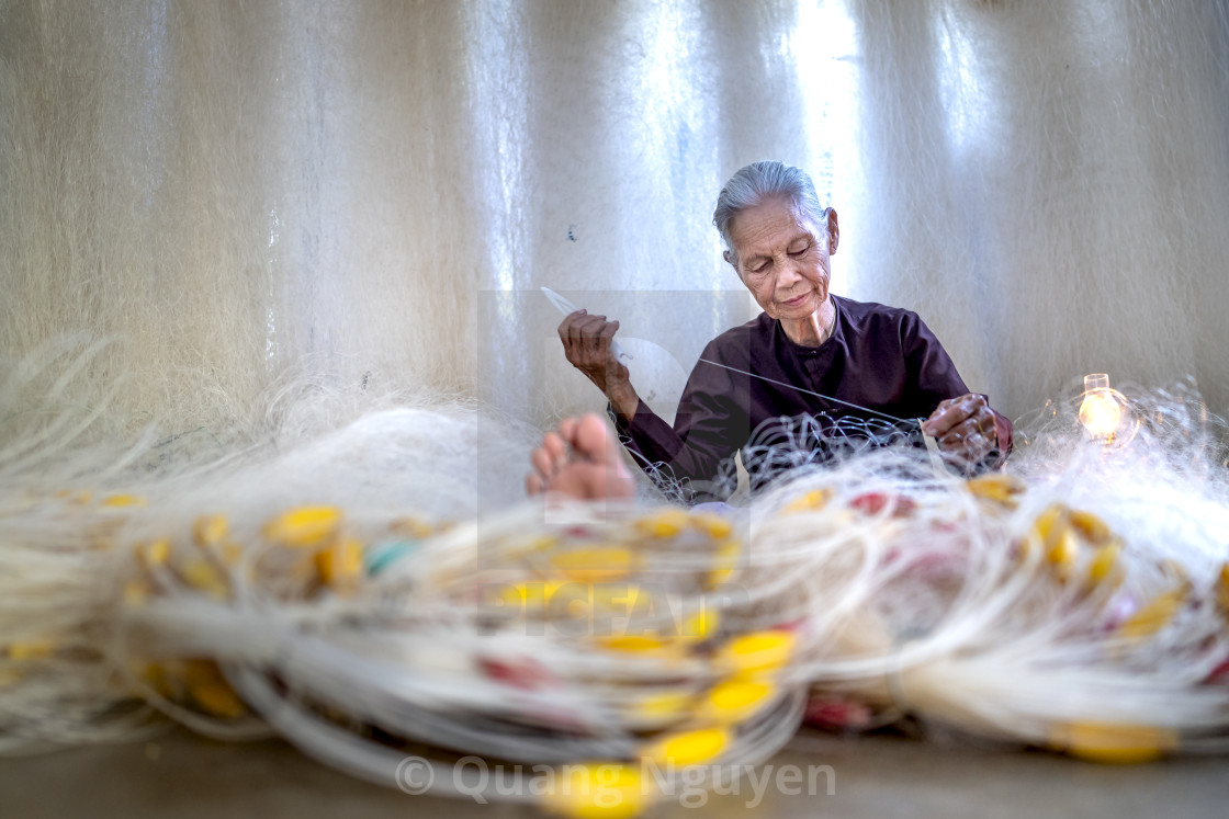 "an elderly woman sitting mending a fishing net" by Quang Nguyen - $43.35 "an elderly woman sitting mending a fishing net" stock image