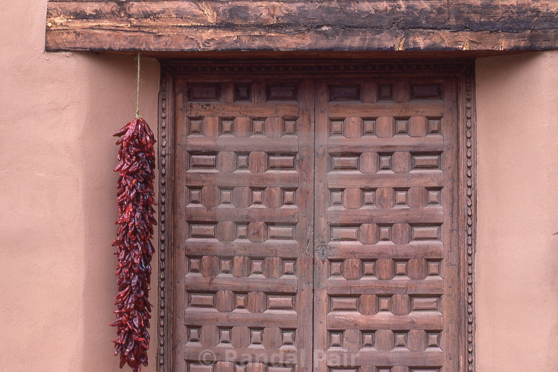 "Carved wood door at adobe chapel" stock image