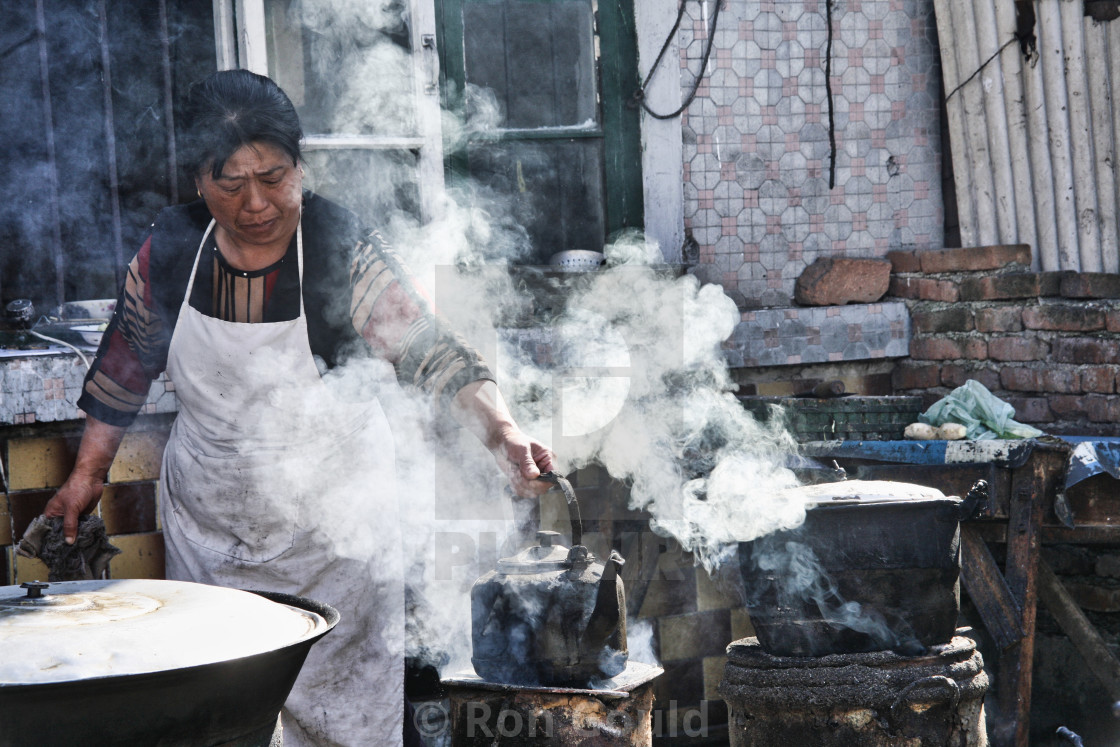 "Woman cooking in market" stock image