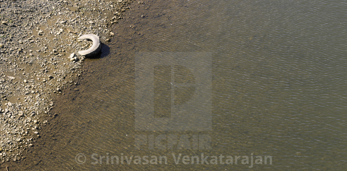 "Tire on the river bank" stock image