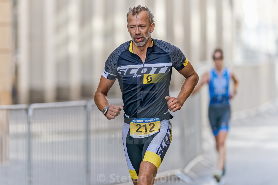 "Closeup of a triathlete running at ITU World Triathlon event in" by Stefan Holm - $6.35 "Closeup of a triathlete running at ITU World Triathlon event in" stock image