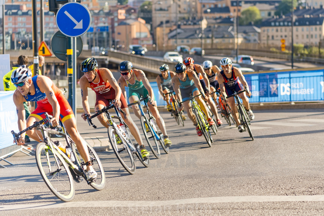 "Group of male triathletes on bicycles in a curve at the Men's IT" by Stefan Holm - $6.34 "Group of male triathletes on bicycles in a curve at the Men's IT" stock image