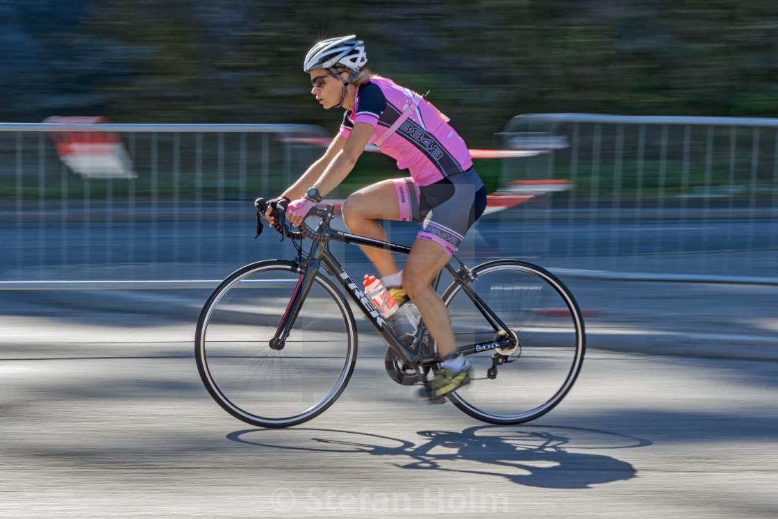 "Female triathlete in pink cycling with motion blur of the pannin" by Stefan Holm - $6.30 "Female triathlete in pink cycling with motion blur of the pannin" stock image