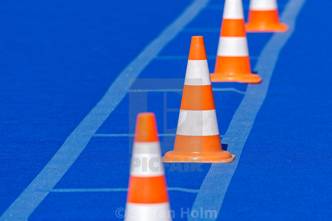 "Orange cones with white stripes on blue mat" by Stefan Holm - $6.32 "Orange cones with white stripes on blue mat" stock image