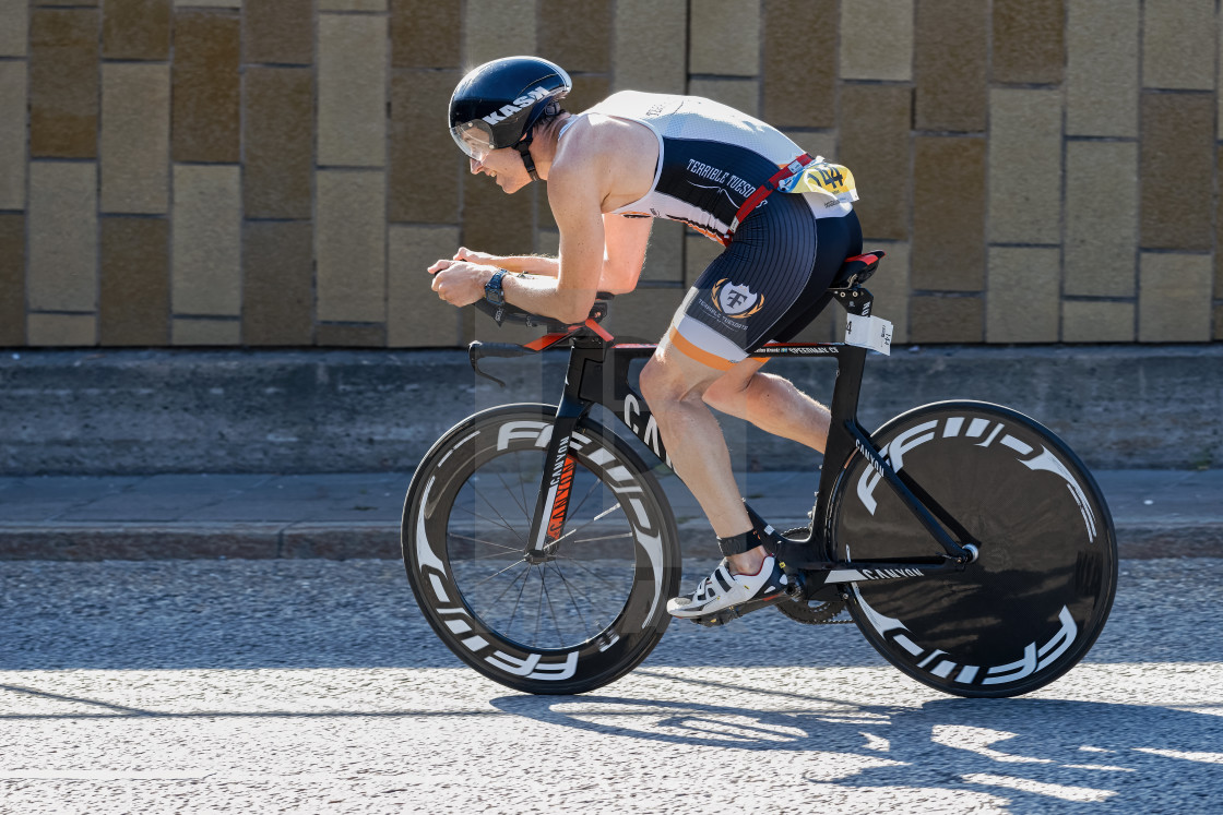 "Triathlete cycling with a speedy bike in partial sunlight at the" by Stefan Holm - $6.30 "Triathlete cycling with a speedy bike in partial sunlight at the" stock image