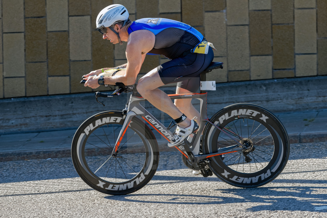 "Triathlete cycling with a speedy bike in partial sunlight at the" by Stefan Holm - $6.30 "Triathlete cycling with a speedy bike in partial sunlight at the" stock image