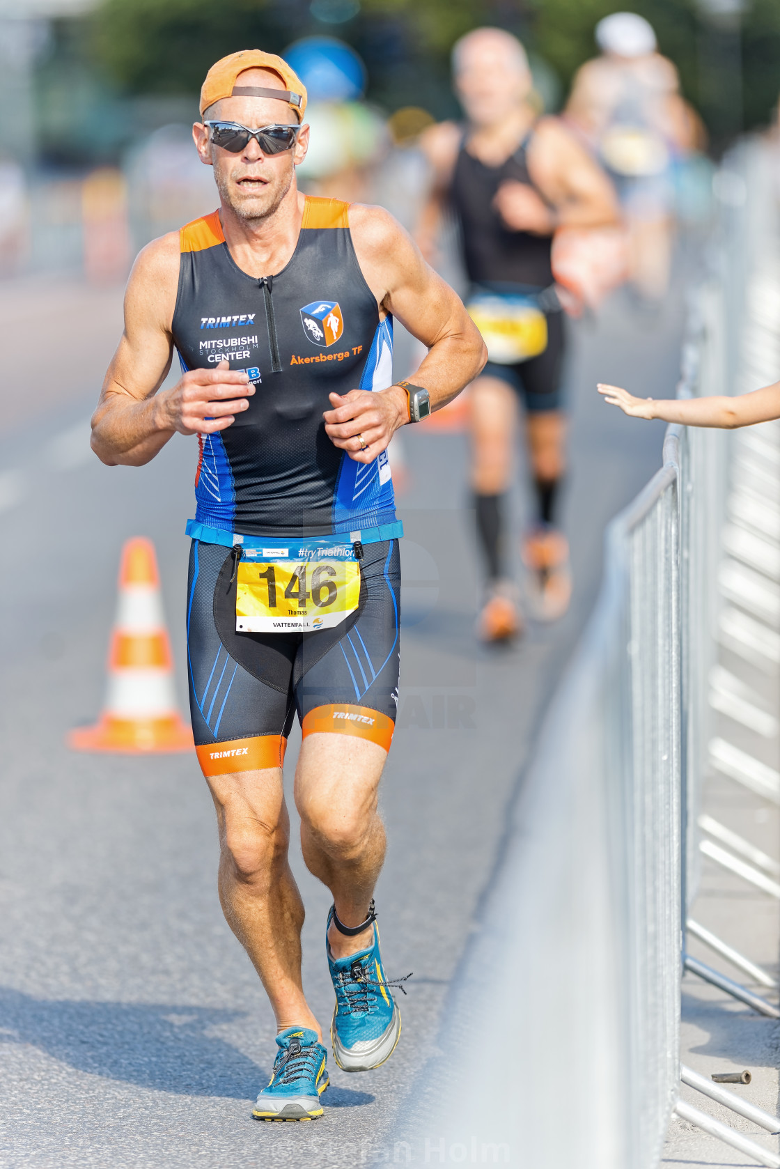 "Triathlete running on asphalt with a kids hand cheering on at IT" by Stefan Holm - $6.32 "Triathlete running on asphalt with a kids hand cheering on at IT" stock image
