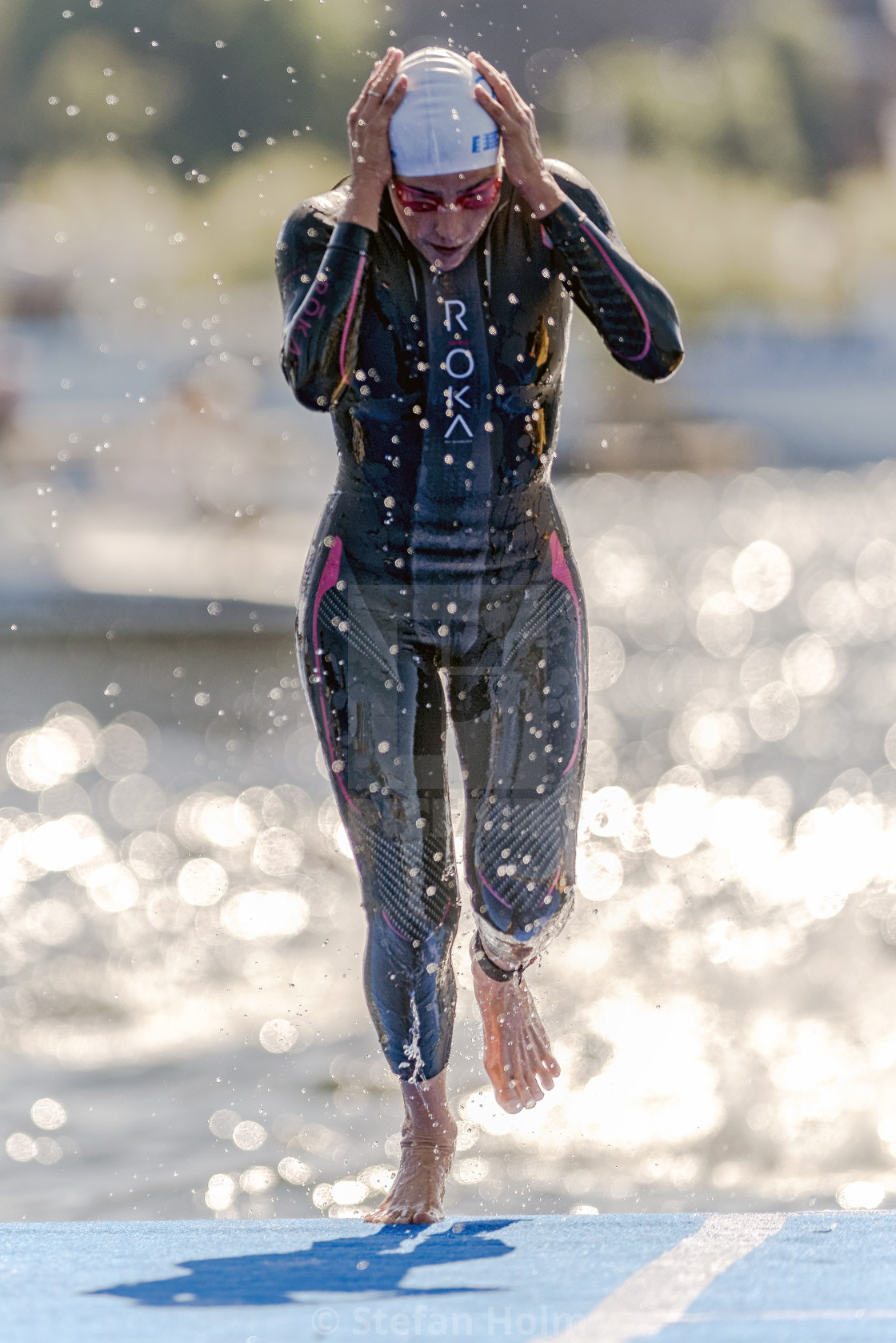 "Triathlete up of the water and adjusting her cap at the Womens I" by Stefan Holm - $6.32 "Triathlete up of the water and adjusting her cap at the Womens I" stock image