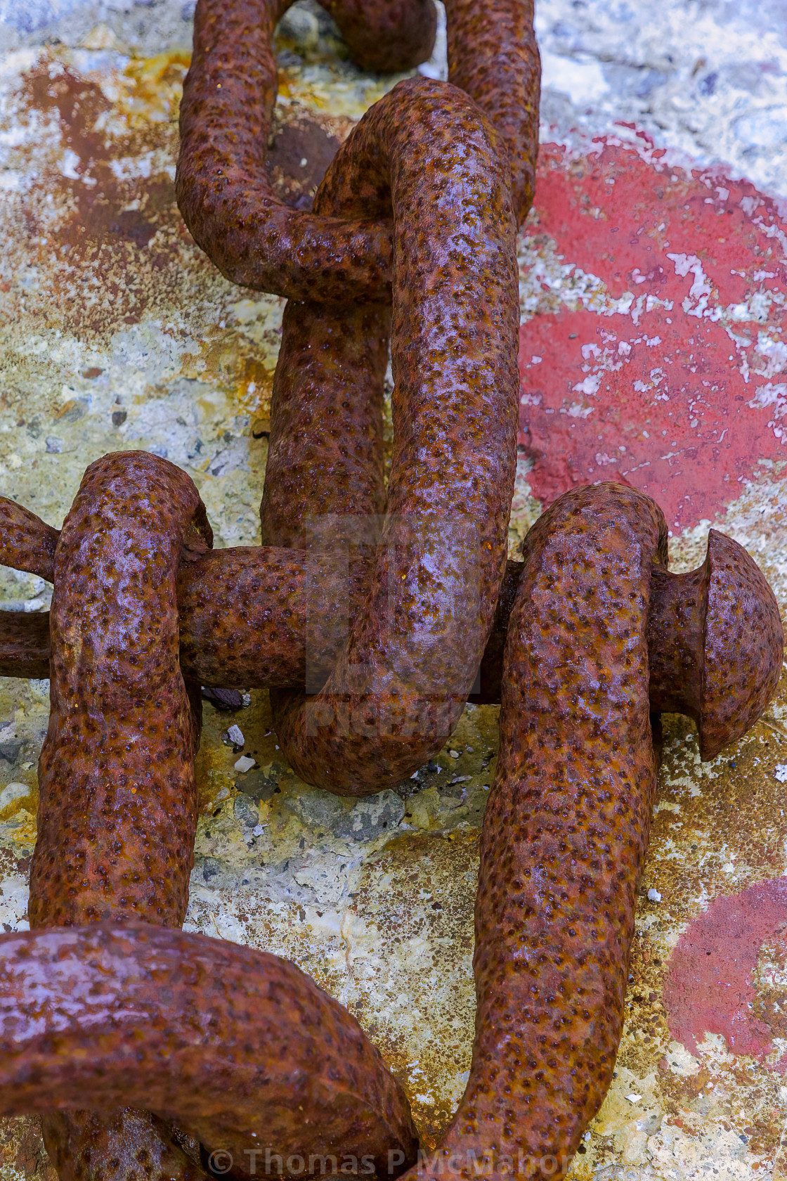 "Rusty chain anchored in a rock." stock image