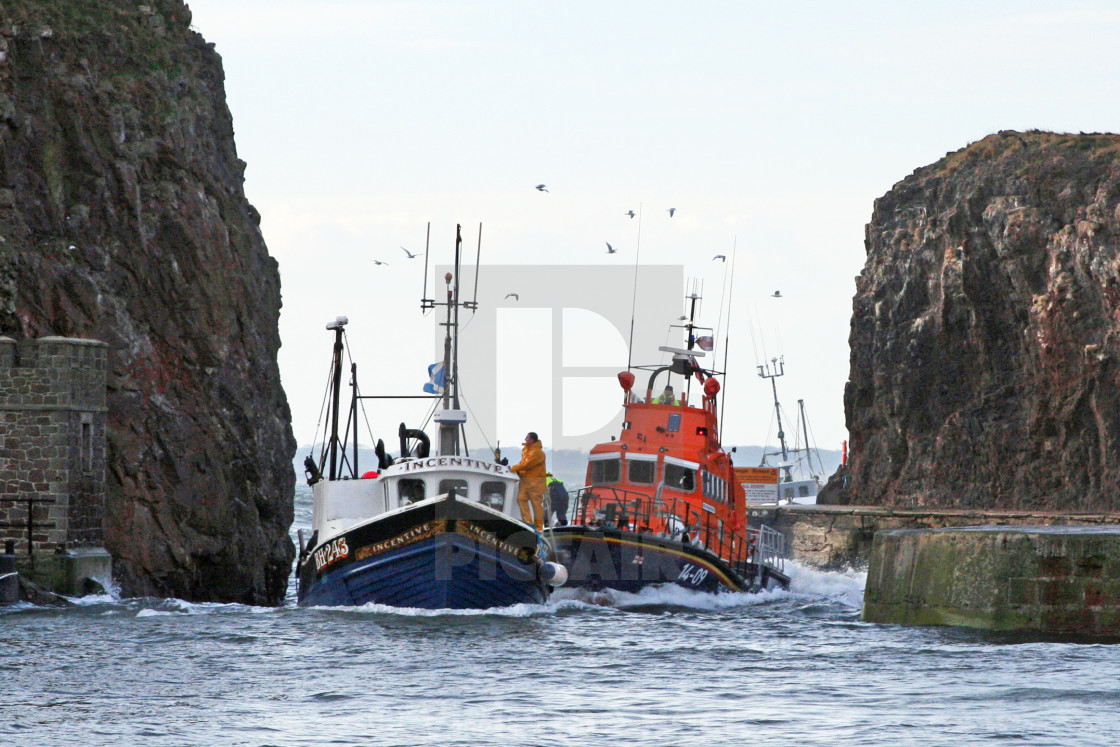 "RNLI Lifeboat escorting a fishing vessel" stock image