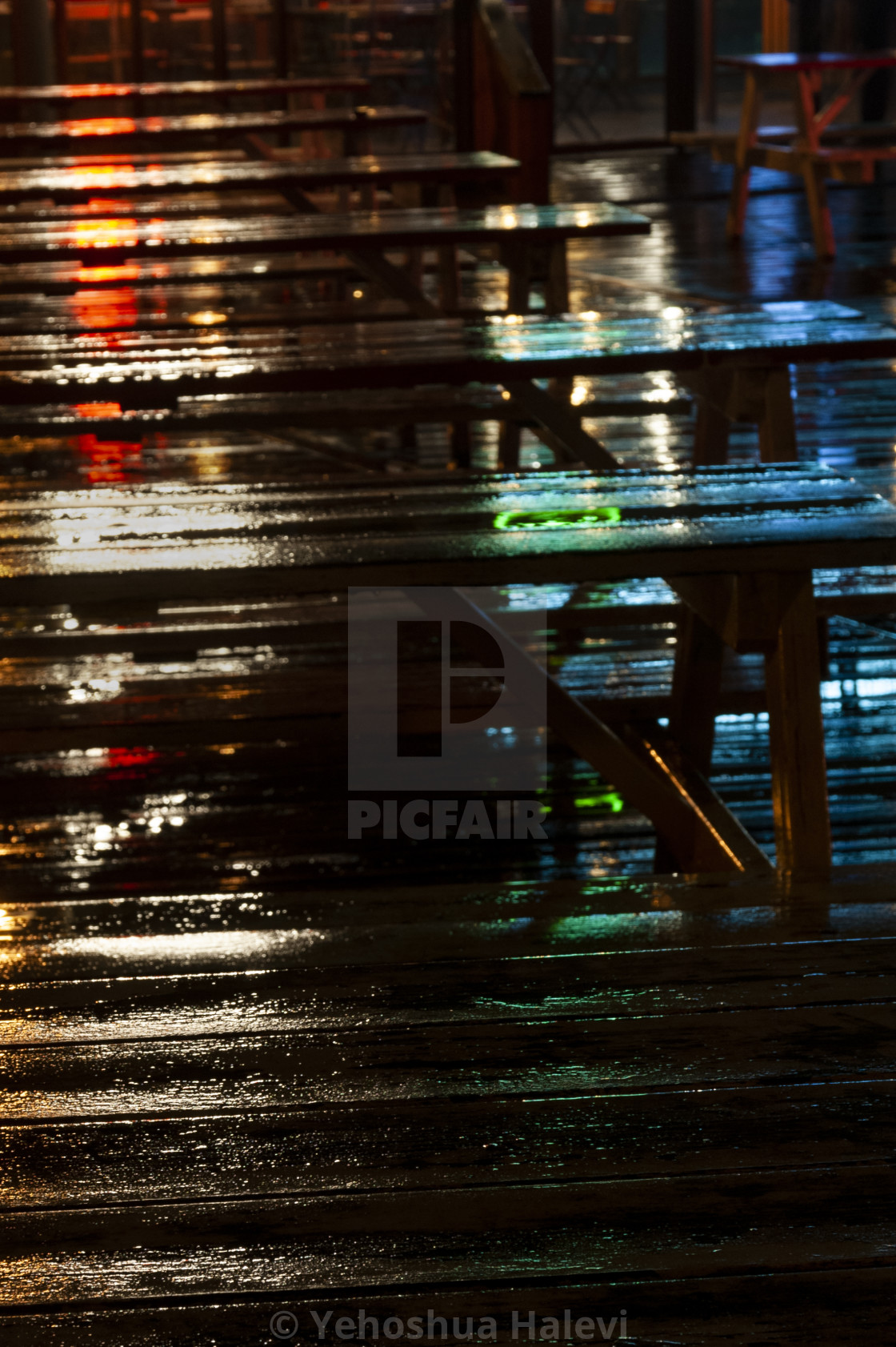 "Bright colored lights on wet picnic tables at night" by Yehoshua Halevi - $4.90 "Bright colored lights on wet picnic tables at night" stock image