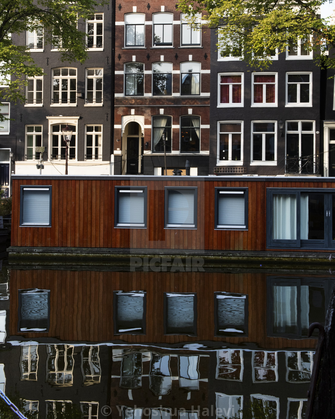"A houseboat and building reflected in a still canal in Amsterdam" by Yehoshua Halevi - $6.08 "A houseboat and building reflected in a still canal in Amsterdam" stock image