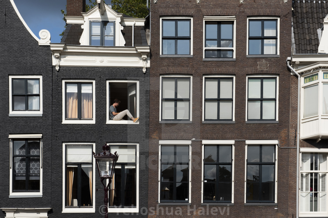 "Sunbathing and reading in an open window in Amsterdam" by Yehoshua Halevi - $6.08 "Sunbathing and reading in an open window in Amsterdam" stock image
