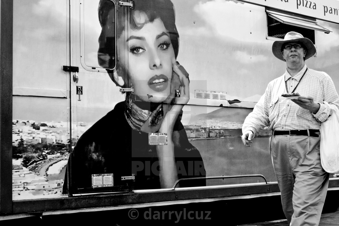 "A amn carrying a pizza wanders past a picture of Sophia Loren on a pizza van in Brighton, UK." by darrylcuz - £6.20 "A amn carrying a pizza wanders past a picture of Sophia Loren on a pizza van in Brighton, UK." stock image