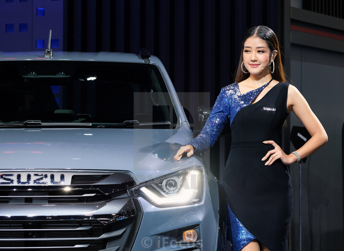 "Pretty presenter stands next to a car" stock image