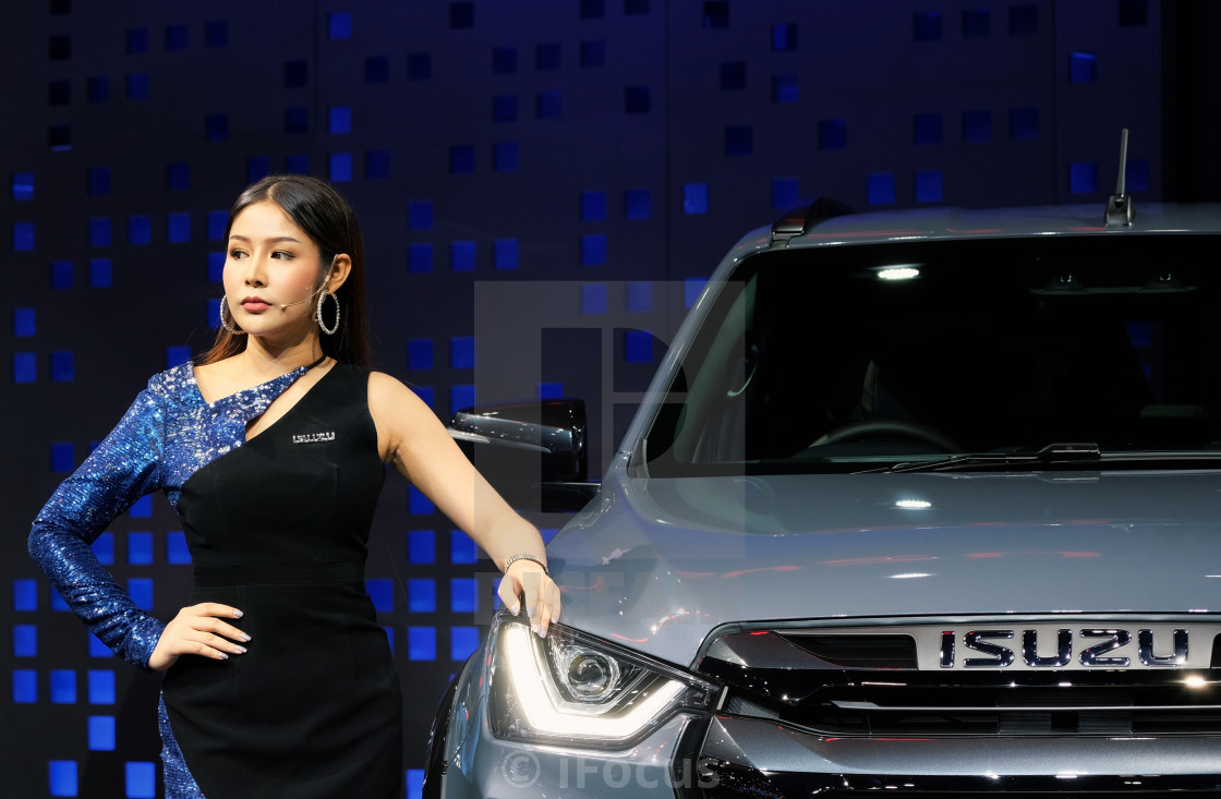 "Pretty presenter stands next to a car" stock image