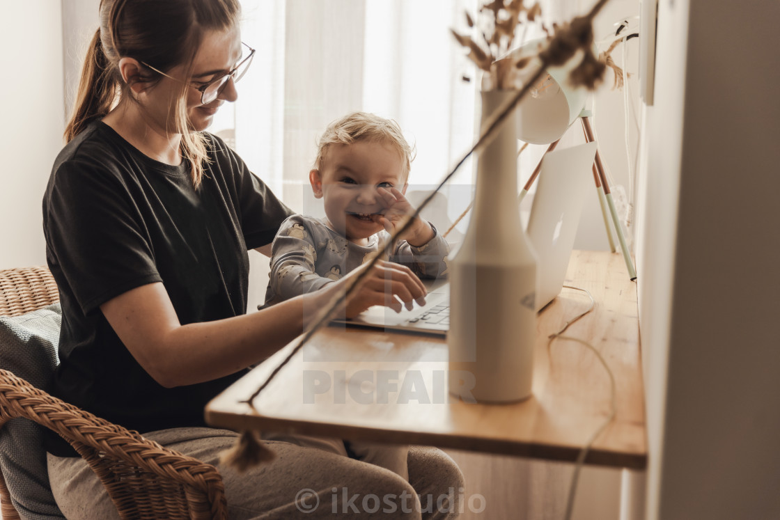 "Woman working at home with her baby" stock image