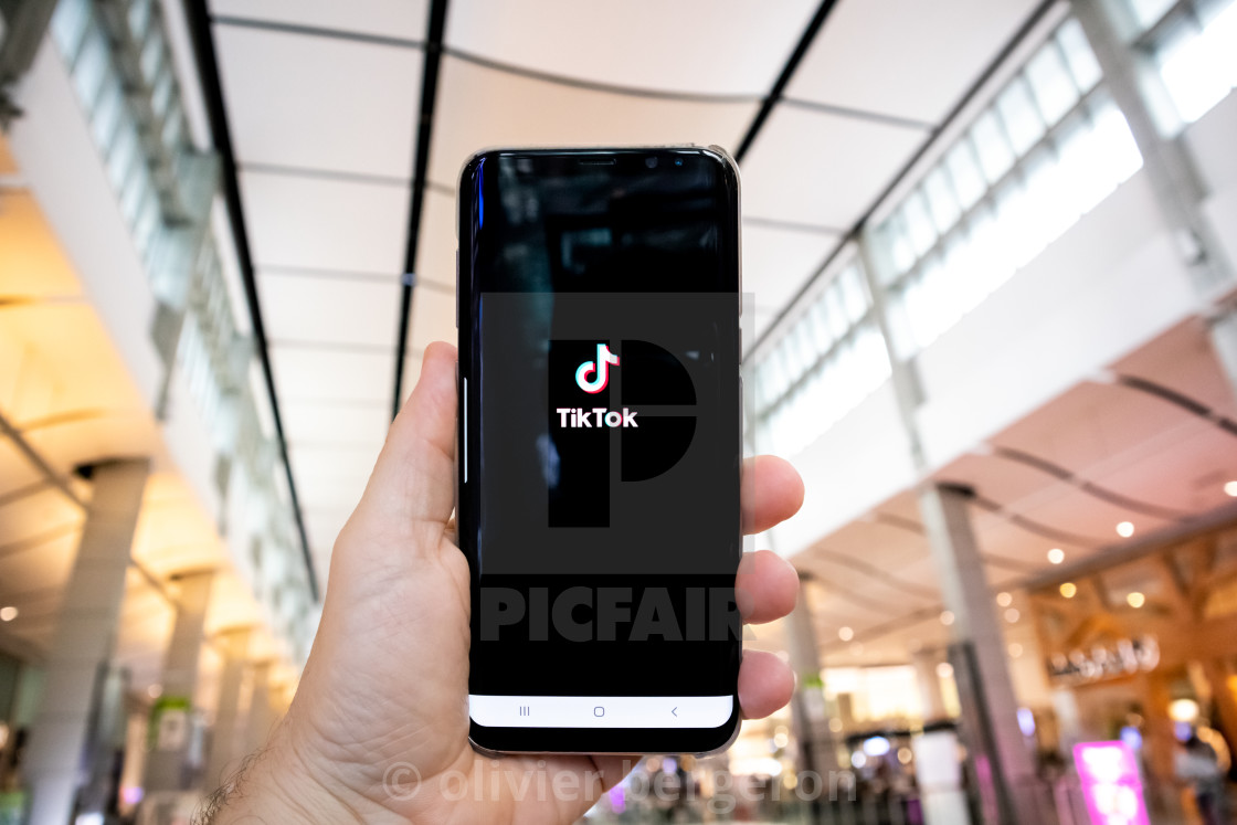 "Man hand holding smartphone with tik tok application open in sho" by olivier bergeron - $17.11 "Man hand holding smartphone with tik tok application open in sho" stock image