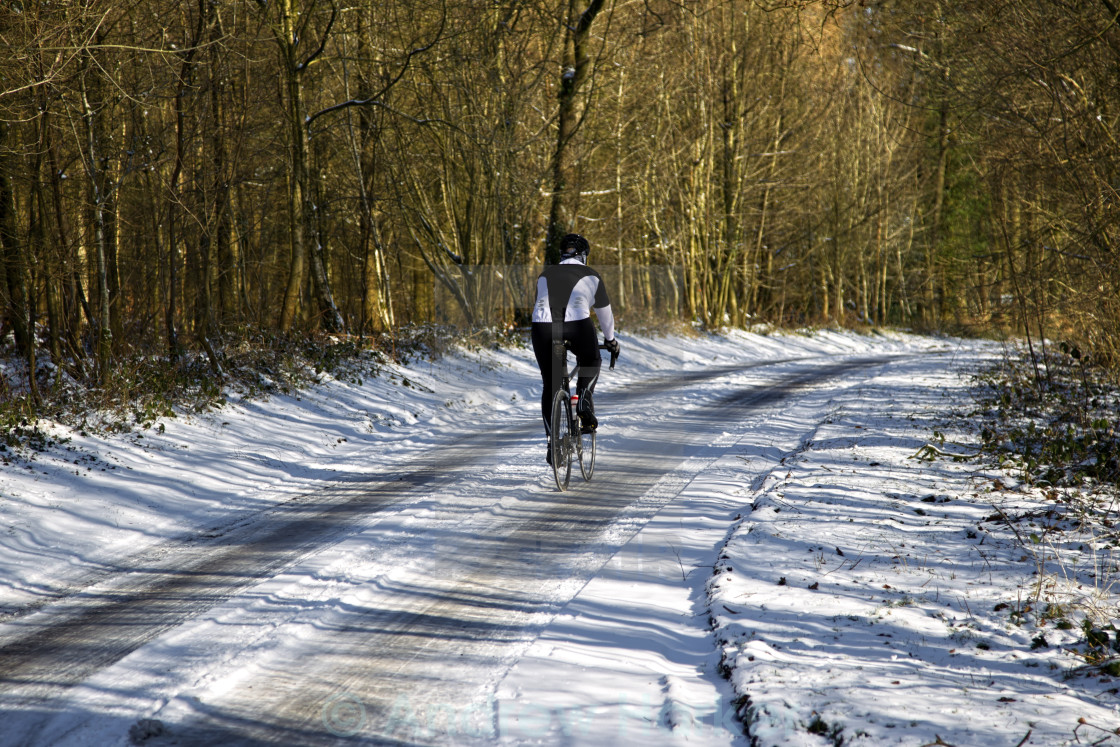 "A male cyclist riding along a snow covered countryside road in winter" by Andrew Harker - $15.16 "A male cyclist riding along a snow covered countryside road in winter" stock image