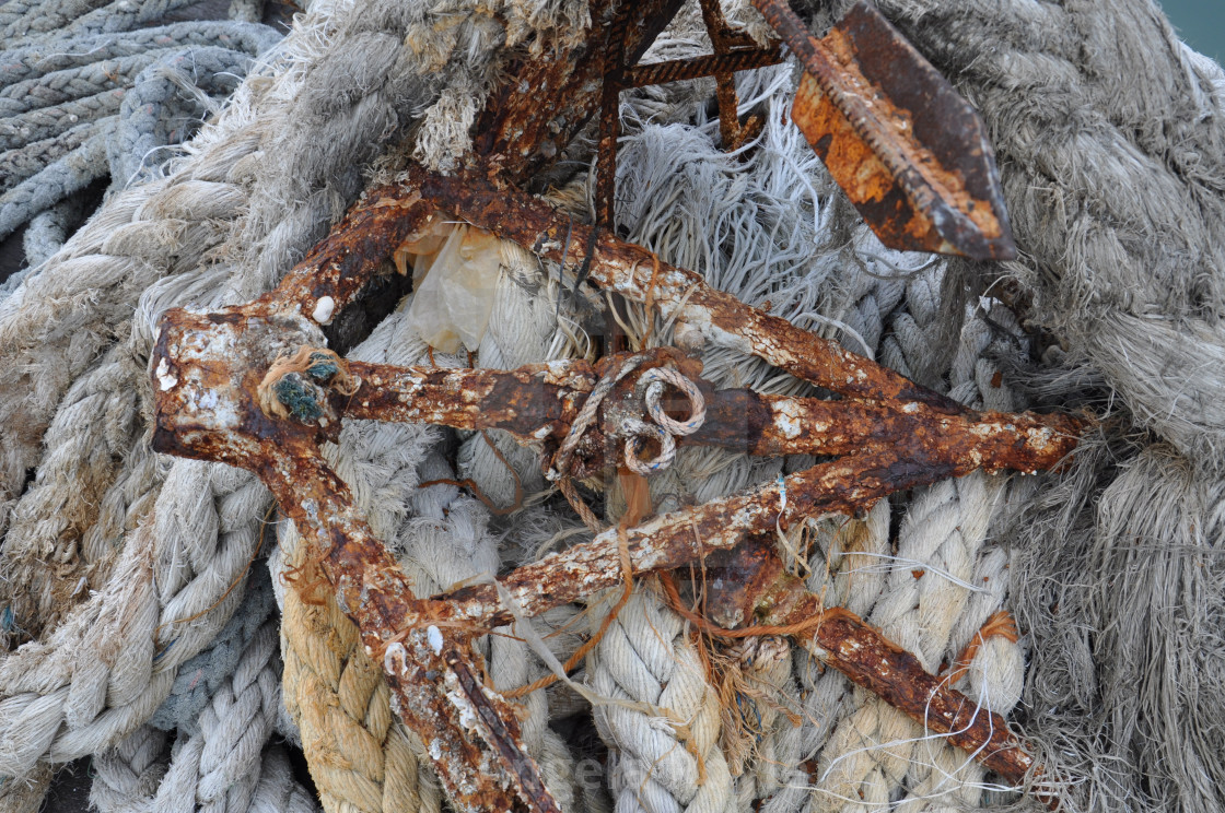 "Rusty anchor and old rope." stock image