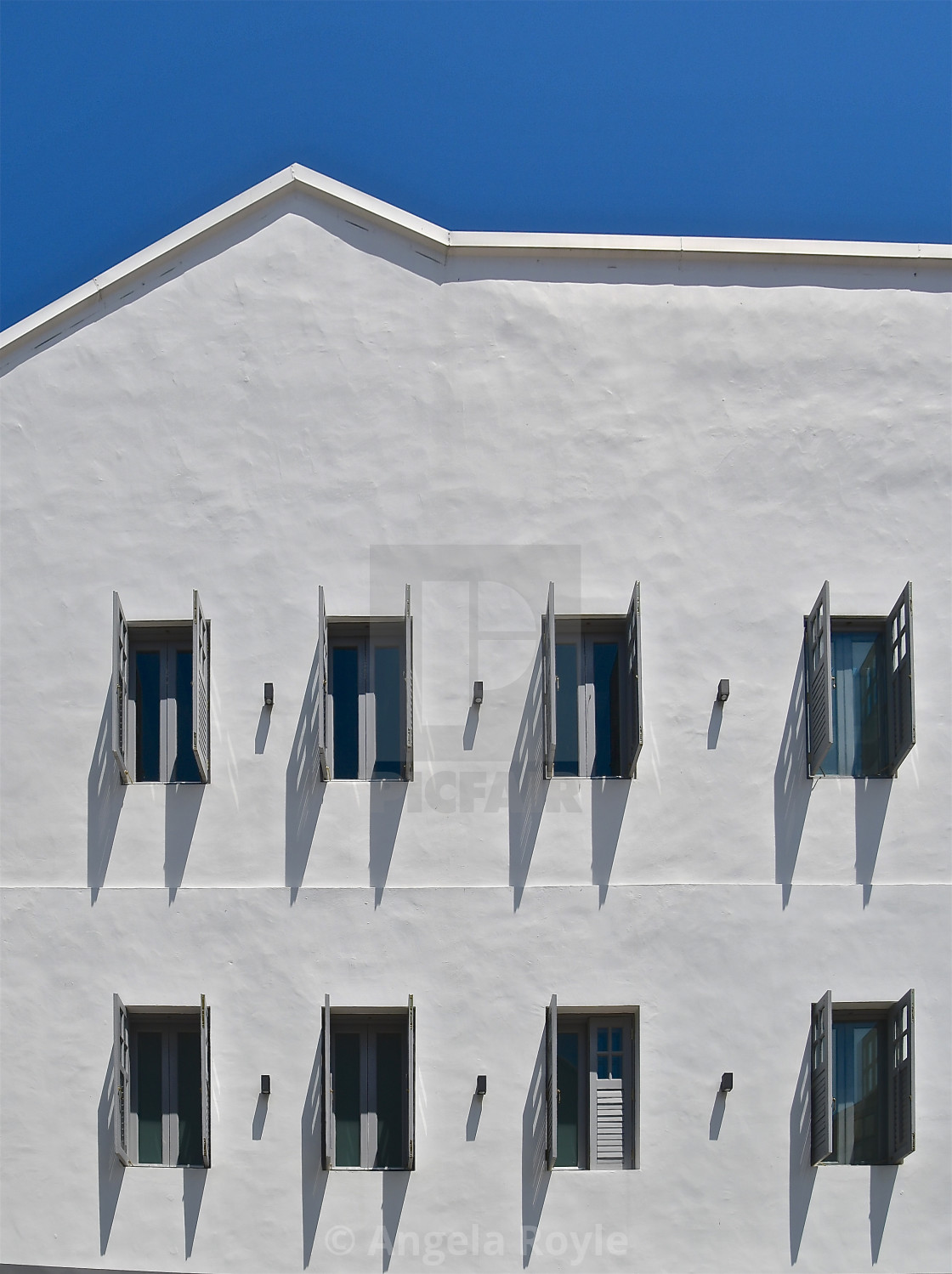 "White shuttered wall and blue sky" stock image