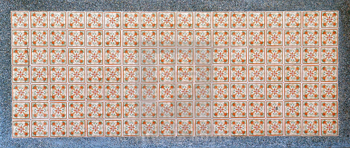 "Green and orange floral tiles with grey stone border." stock image