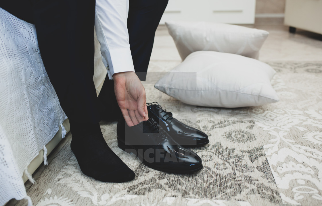 "Man in a suit ties up shoelaces on black classic elegant shoes." by Antonio Gravante - $10.72 "Man in a suit ties up shoelaces on black classic elegant shoes." stock image