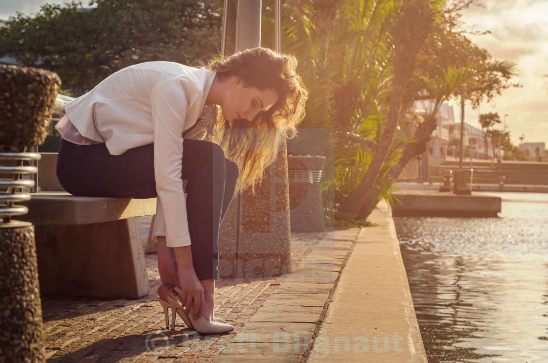 Beautiful Young Woman In Jeans And A Jacket Putting Her Shoes On