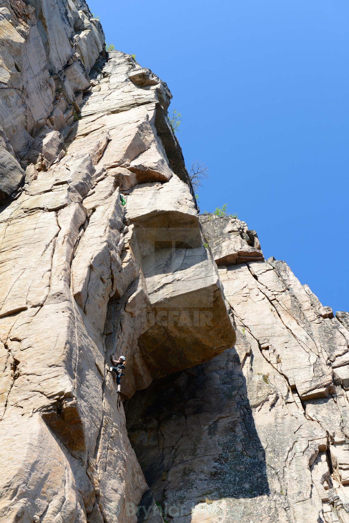 "climbing up a steep rock" stock image