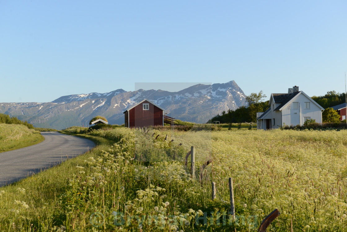 "Houses in a field with mountain behind" stock image