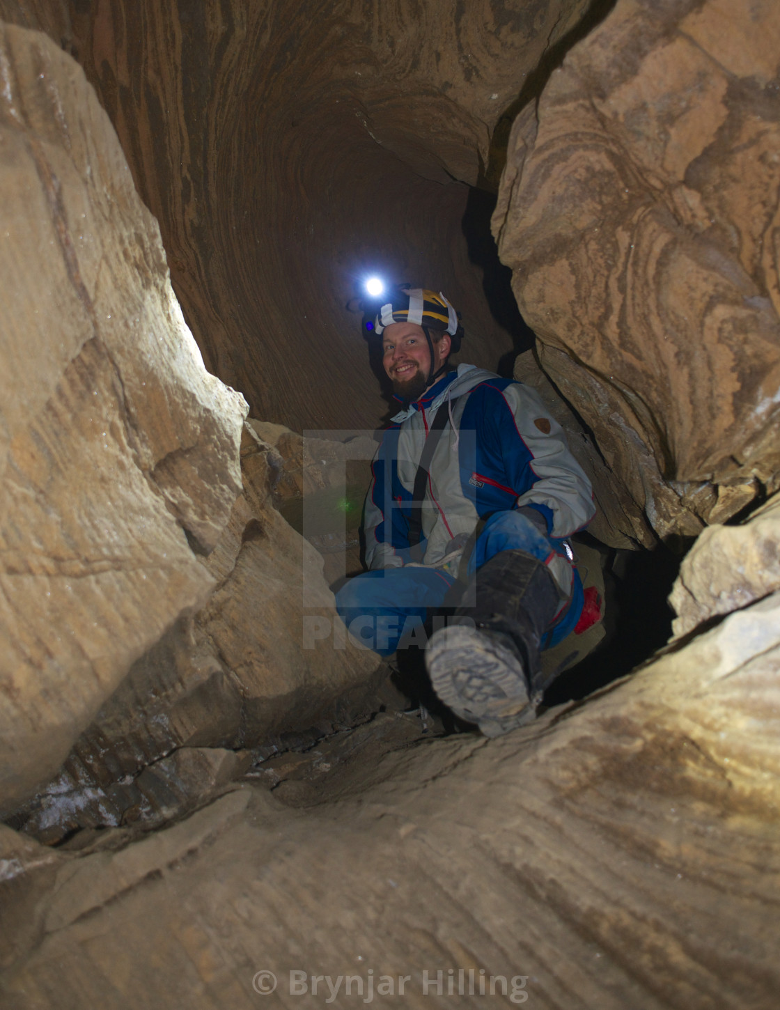 "Man caving with headlamp on" stock image