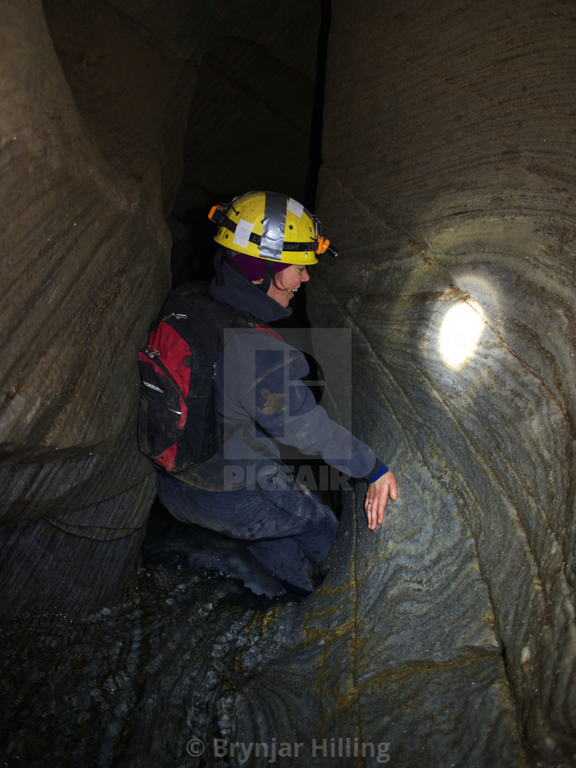 "Woman caving with headlamp" stock image