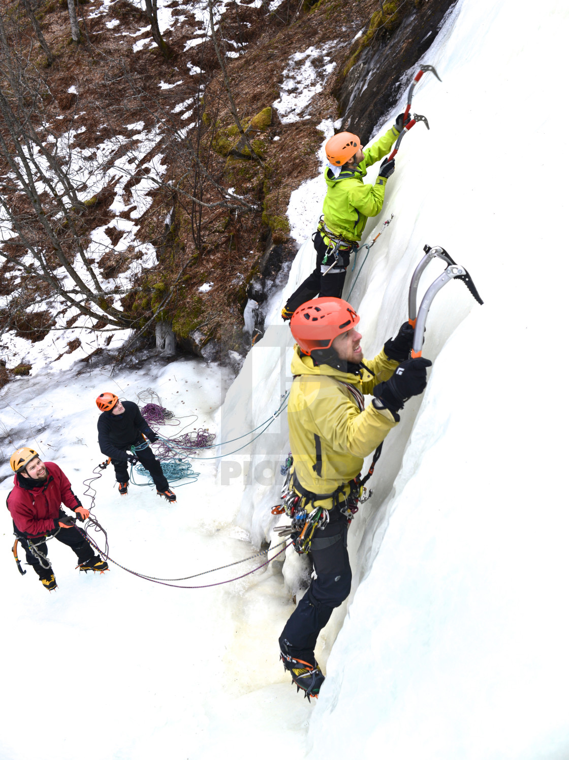 "Men climbing ice with colorful gear" stock image