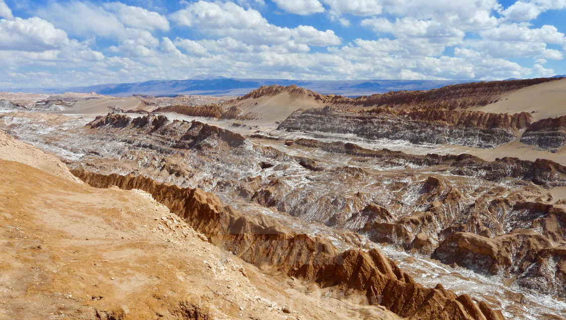 "Yellow sand and rocks with bright blue sky and withe clouds in Peru." stock image