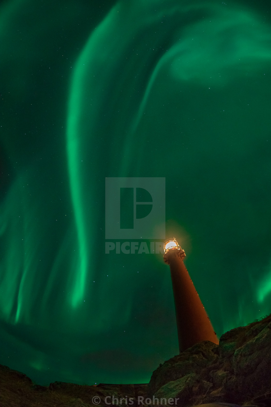 "Northern lights over a lighthouse" stock image