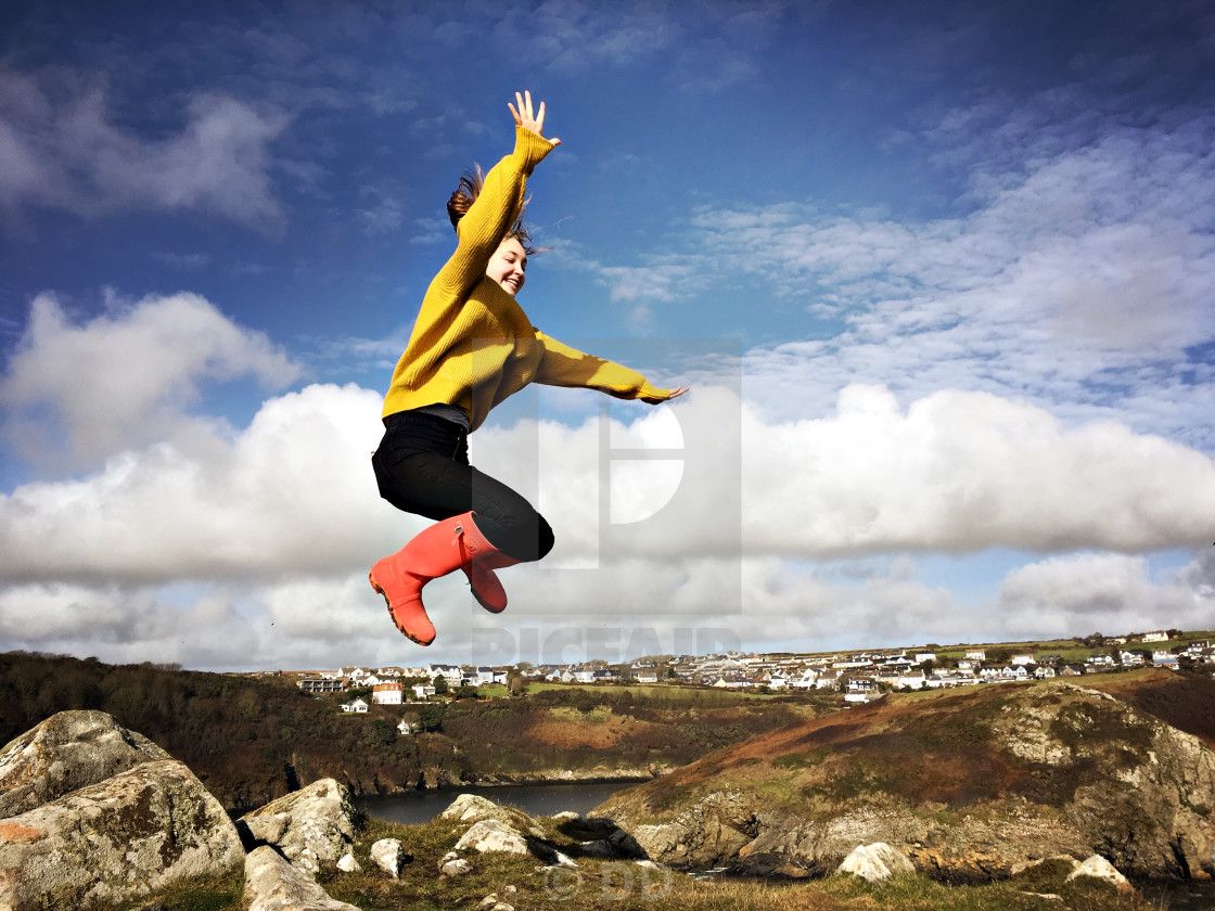 "A teenage girl jumps off a rock in Solva, Wales" by DD - $10.82 "A teenage girl jumps off a rock in Solva, Wales" stock image