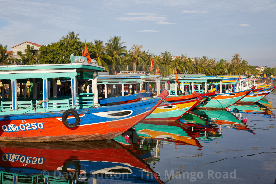 "Tour boats lined up along the quay on the Thu Bon River, Hoi An, Vietnam" stock image