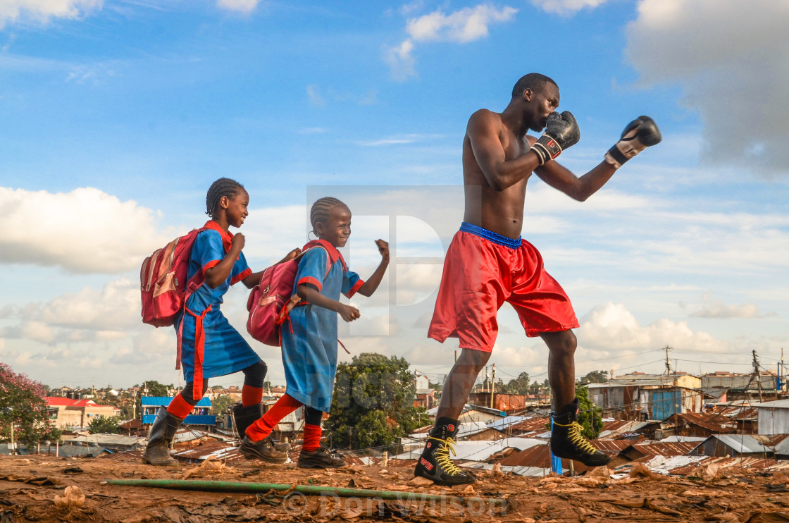 "A local Street Boxer does his daily evening warm ups as two girls happily run after him copying his tricks." stock image