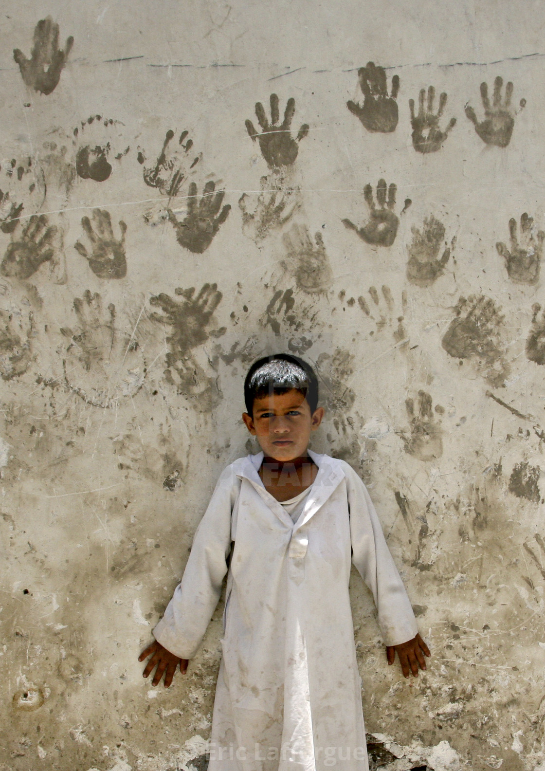 "Child In Front Of A Wall Covered With Handprints To Protect From The Evil..." stock image