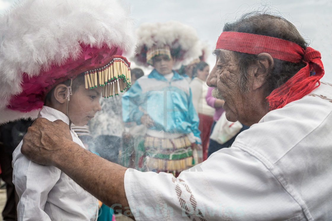 "An old spiritual healer talks to a traditionally dressed young boy in mexico" stock image