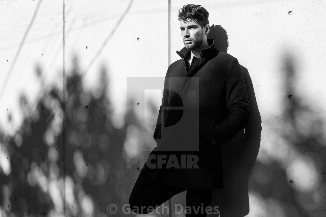 "A black and white portrait of a latin male model standing against a wall in a black coat and trousers" by Gareth Davies - $77.88 "A black and white portrait of a latin male model standing against a wall in a black coat and trousers" stock image