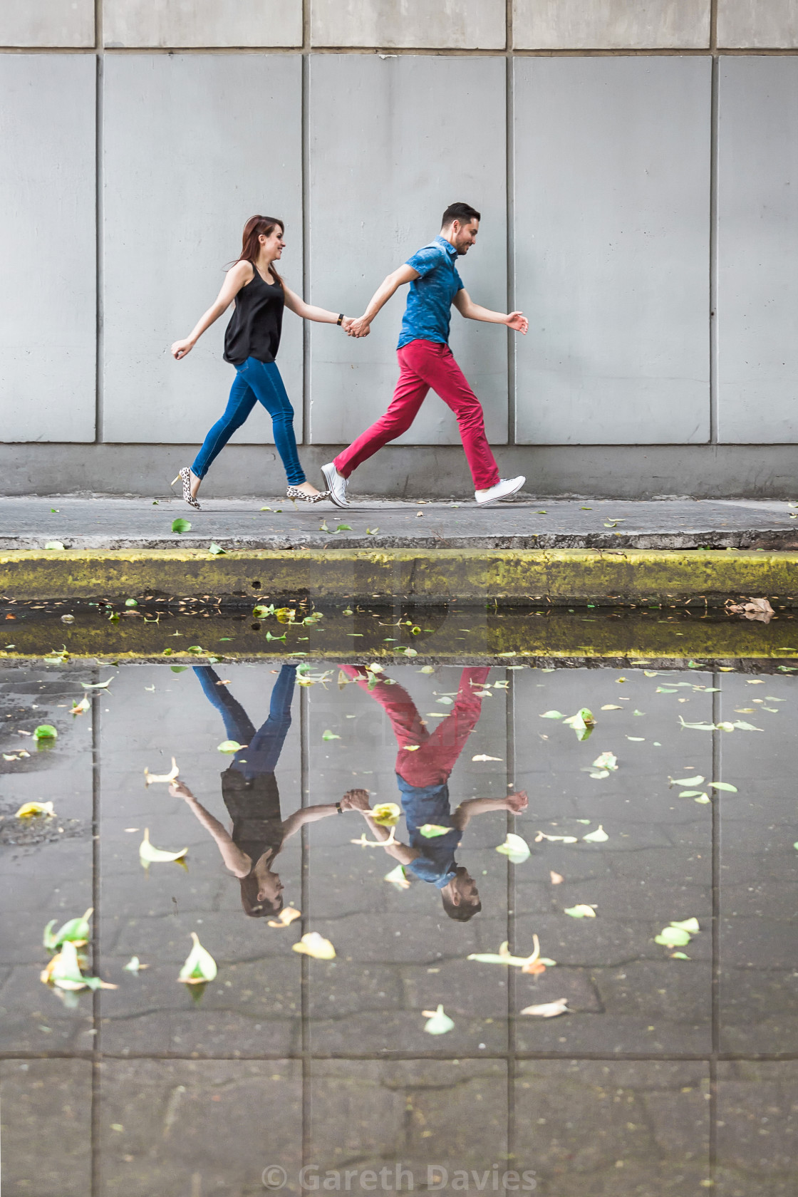 "A latin couple running across a pavement with their reflection in a puddle" by Gareth Davies - $28.04 "A latin couple running across a pavement with their reflection in a puddle" stock image