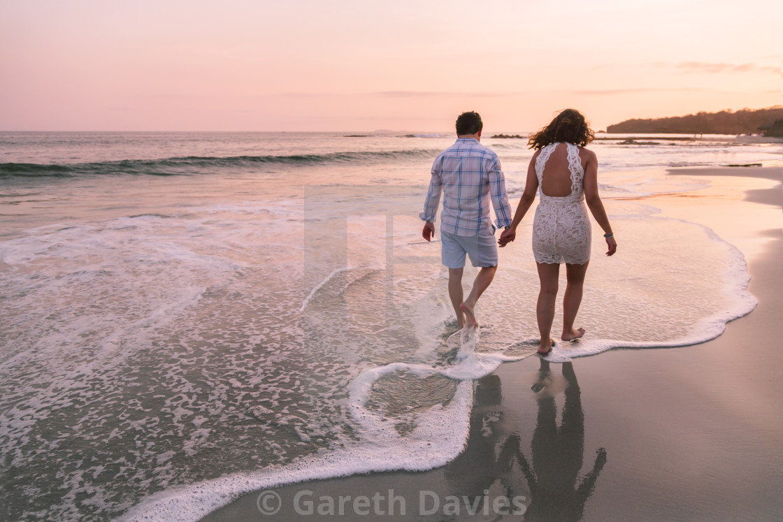 "Young Mexican couple walk along the shoreline on the beach at sunset" by Gareth Davies - $28.04 "Young Mexican couple walk along the shoreline on the beach at sunset" stock image