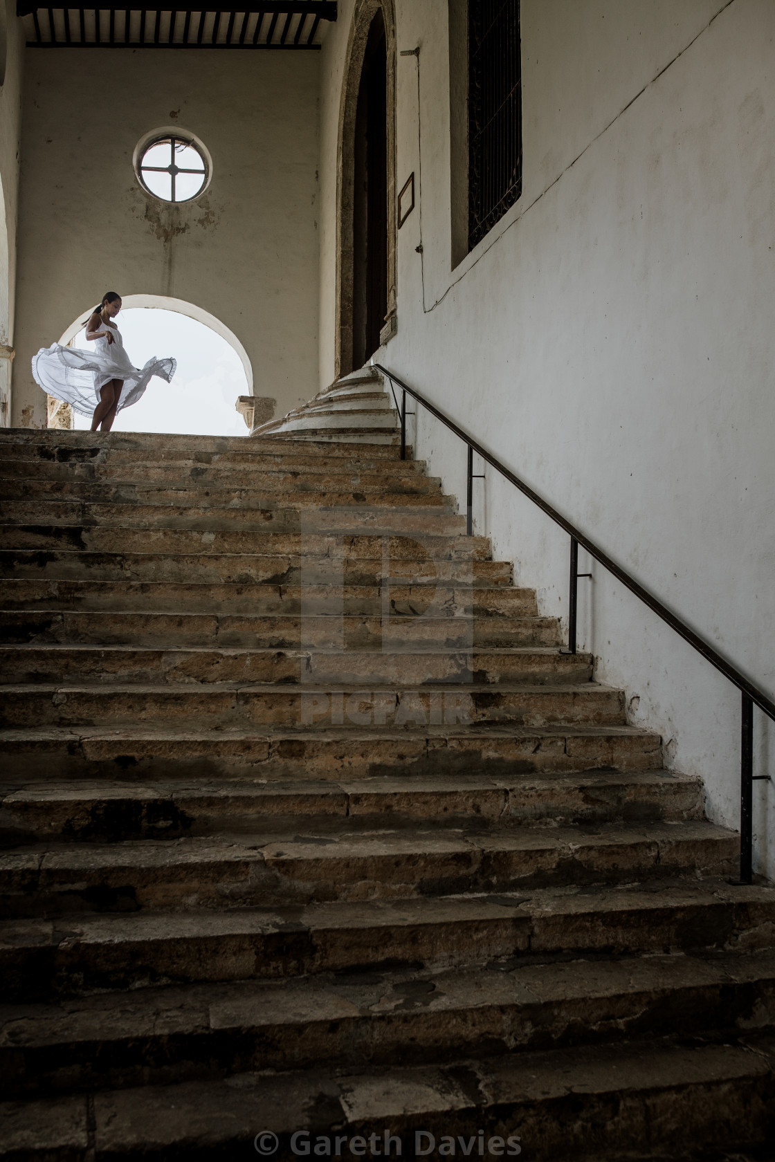 "A lady dancing in a white dress at the top of the stairs in a colonial building" by Gareth Davies - $4.67 "A lady dancing in a white dress at the top of the stairs in a colonial building" stock image