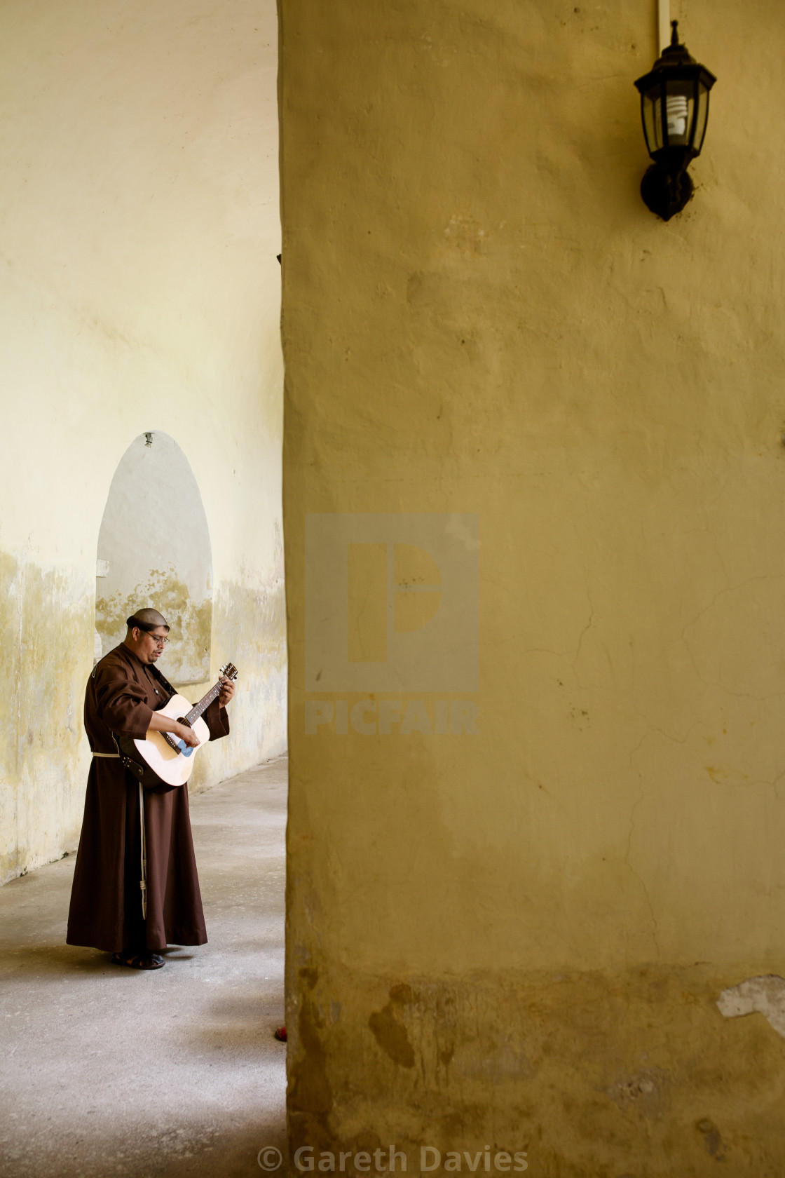 "A franciscan monk plays the guitar in a monastery" stock image