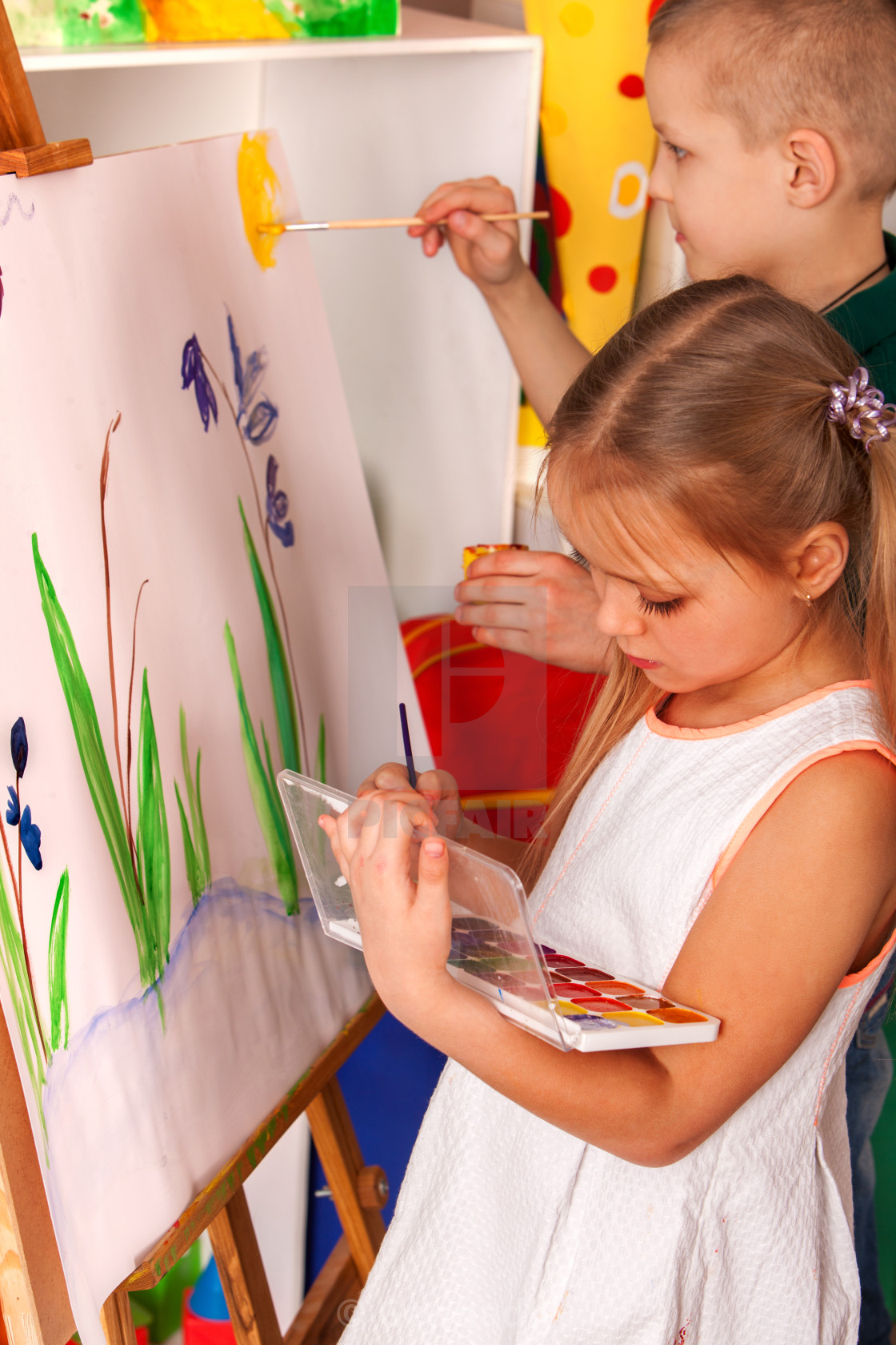 Children Painting Finger On Easel Group Of Kids With Teacher