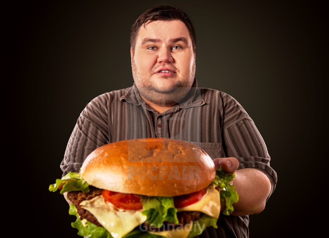 "Fat man eating fast food hamberger. 