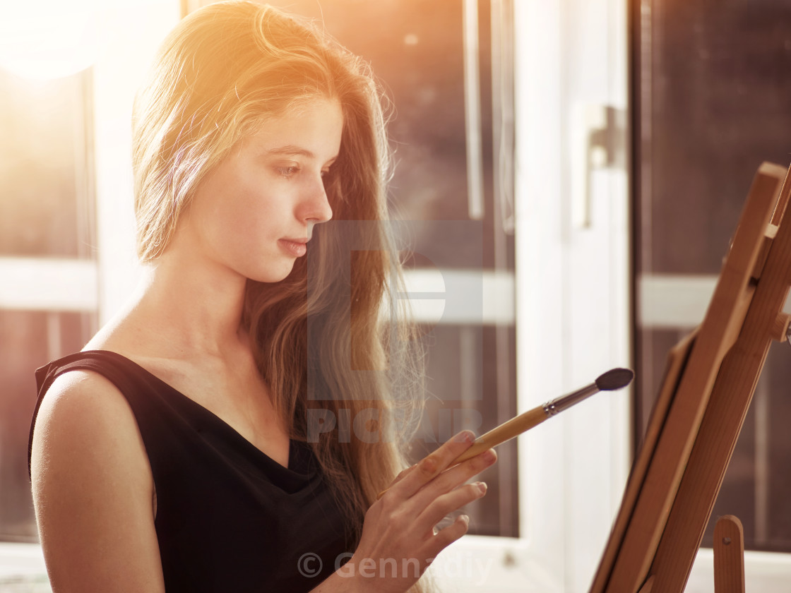 Artist Painting On Easel In Studio Girl Paints With Brush